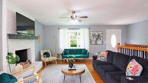 A living room with a fireplace, a sofa, a coffee table, and a ceiling fan. - Spacious 5-bedroom Tallahassee Home / Minutes to FSU & FAMU & The Capitol (Tallahassee)