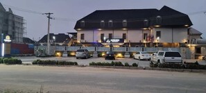 A hotel with a large building, a parking lot, and several cars parked in front. - Rownez Resort (Lagos)