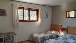 A small, tidy room with two single beds, a desk, and a chair. - Gîte de Pigneux (Saint-Genix-les-Villages)