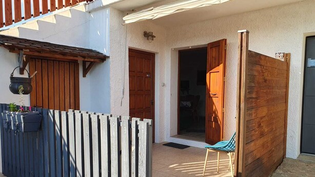 A building with a wooden fence, a door, and a chair outside. - Gîte de Pigneux (Saint-Genix-les-Villages)
