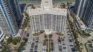 Un hôtel de grande hauteur doté d’une cour intérieure, d’un parking et offrant une vue sur la plage.