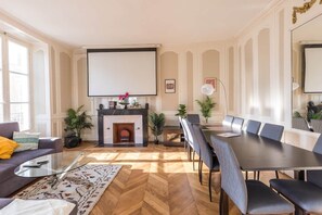 A modern living room with a fireplace, a dining table, and comfortable seating.