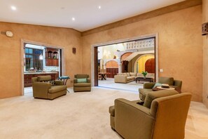 A spacious living area with sofas, a coffee table, and a kitchen visible through an open doorway. - Château Cerritos | Luxe Oceanfront Home (La Paz)