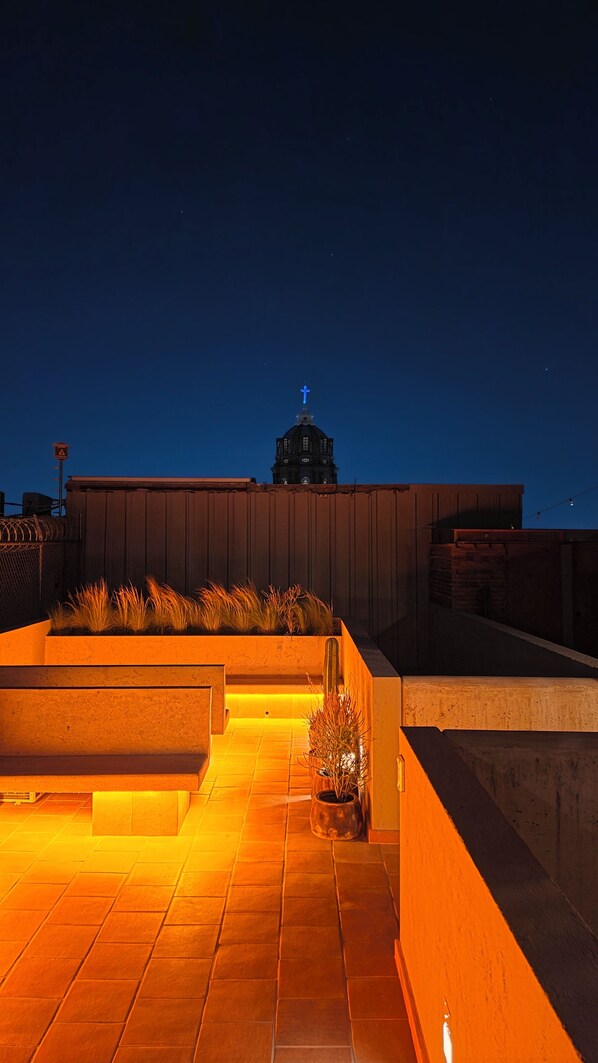 A rooftop terrace with a view of a church steeple, a potted plant, and a tiled floor. - Loft 5 Min Fan Festival Guadalajara Centro Catedral Pet Friendly S1 (Guadalajara)