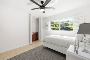 A bedroom with a bed, a nightstand, a lamp, a ceiling fan, and a window with shutters. - Peaceful Family &Pet friendly 3-bedroom Pool house in beautiful Naples (Naples)
