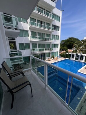 Apartment, Balcony, Pool View | Desk, laptop workspace, iron/ironing board, cribs/infant beds