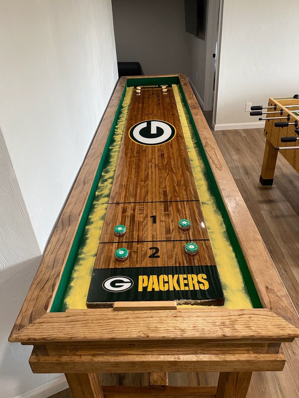 A foosball table with a Packers logo and a power button.