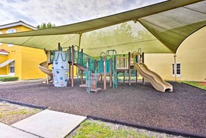 A playground with climbing structures, slides, and a shaded area. - Comfortable Home at Berkley Resort (Kissimmee)