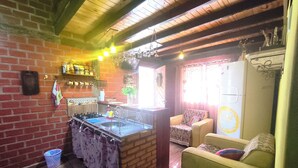 Un salon chaleureux avec une cuisine, un plafond en bois et un canapé vert.
