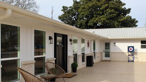 Un edificio con ventanas amplias, una puerta y una diana en el suelo.