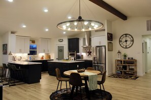 A spacious kitchen with a large island, modern appliances, and a dining area with a round table and chairs.