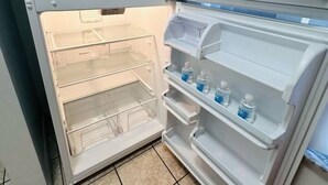 Un réfrigérateur propre et vide, doté de plusieurs étagères et d’un compartiment congélateur.