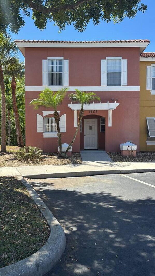 A two-story building with a red and yellow facade, numbered 1103. - Your next adventure 3 (Kissimmee)