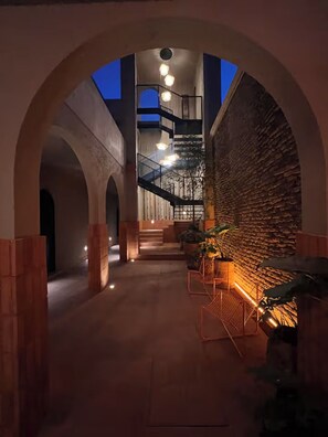 Ein modernes Interieur mit einer zentralen Treppe, gewölbten Decken und einer Ziegelwand.