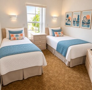 A hotel room with two beds, a window with a view, and wall-mounted artwork. - Kissimmee Value Townhouse w/ Direct Pool Access (Kissimmee)