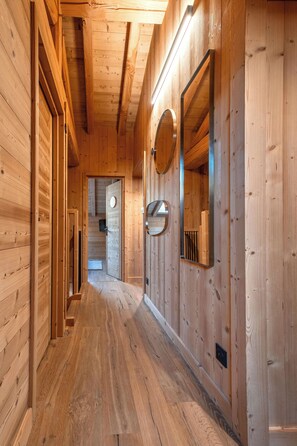 A wooden hallway with a wooden floor, a door at the end, and a mirror on the wall. - Chalet 14p - Jacuzzi - Lift - Sport - 300m from the slopes - Centre les 2 Alpes (Les Deux Alpes)