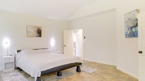 Ein Schlafzimmer mit einem Bett, Nachttischen und Bildern an den Wänden.