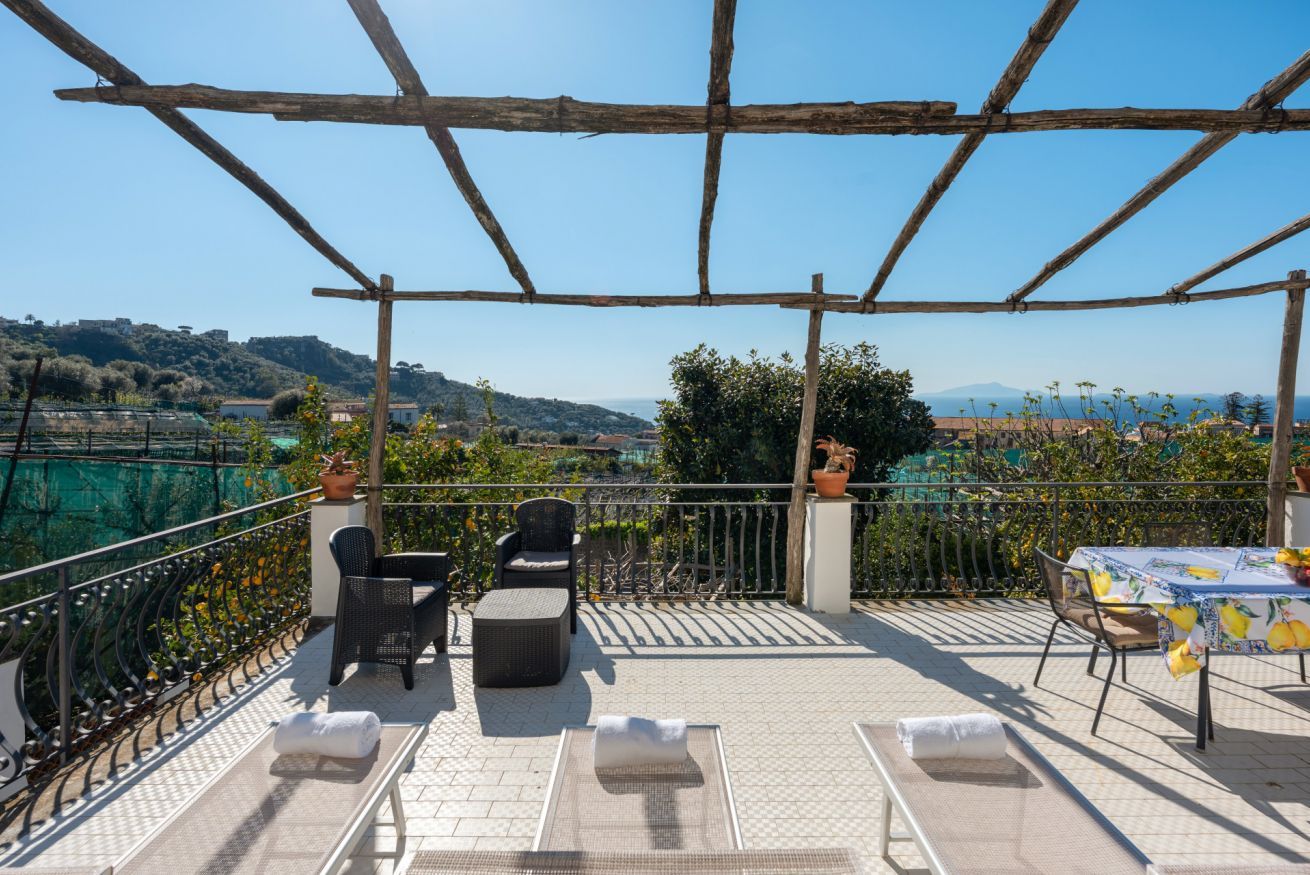 Une terrasse avec des sièges extérieurs, une pergola et une vue sur le paysage.