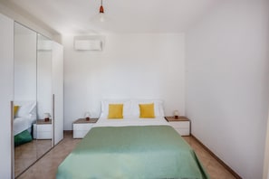 A bedroom with a bed, bedside tables, a mirror, and a hanging light fixture. - SorrentoVibes - The Lemon Grove Villa with private pool, garden and terrace (Massa Lubrense)
