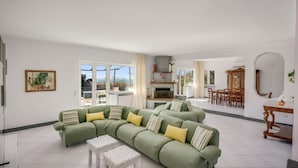 Una sala de estar con un sofá verde, una mesa de centro blanca y una chimenea.