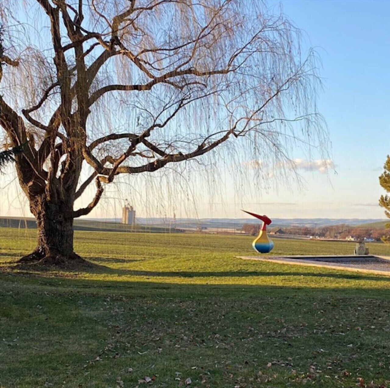 Ett träd med en skulptur av en fågel i en park.