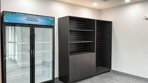 Une pièce équipée d’un réfrigérateur de type «
bodega
» et d’une armoire avec plusieurs étagères.