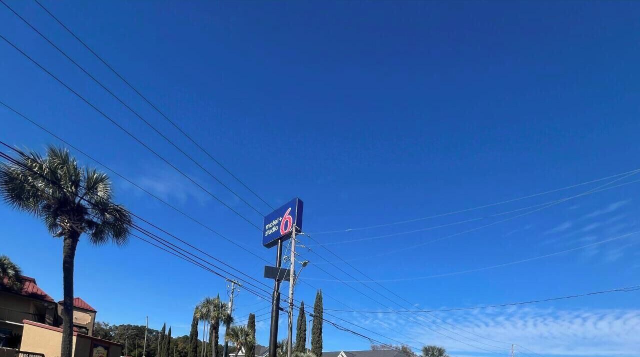 A clear blue sky with a Model Studio sign on a pole.
