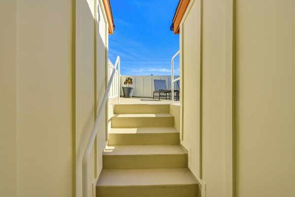 A set of beige stairs leading to a balcony with a view of the sky and a potted plant. - 1 Mi to Beach! San Clemente Gem w/ Rooftop Patios (San Clemente)