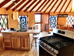 Una cocina rústica con armarios de madera, estufa a gas y una isla grande con fregadero.