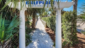 Un sendero que conduce a una zona de playa privada, señalizada con un cartel.