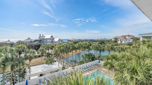 Un resort con piscina, palmeras y vistas al océano.