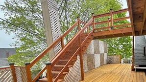 Une terrasse en bois avec un escalier menant à un niveau supérieur.