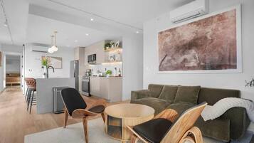 Suite superior, 3 habitaciones, balcón | Área de sala de estar | Televisión de 50 pulgadas con canales digitales