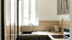 Una cocina moderna con un lavamanos integrado, una cafetera Bosch y un ventanal que proporciona luz natural.