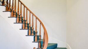 A staircase with wooden balusters and blue carpeted steps.