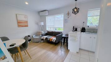 A compact living space with a kitchenette, a dining area, and a sofa.