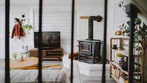 A cozy living room with a TV, a wooden table, a sofa, a fireplace, and a bookshelf. - Mt. Rainier Getaway (Ashford)