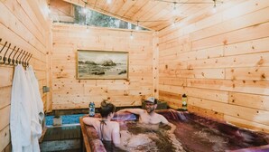 A wooden cabin with a hot tub, wooden walls, and a painting. - Mt. Rainier Getaway (Ashford)