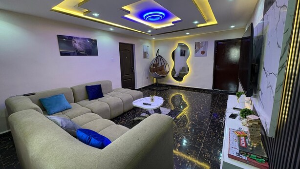 A modern living room with a sectional sofa, a round coffee table, and a hanging chair. - A few steps away from the famous acropolis park, located in the heart of Apo! (Federal Capital Territory, Nigeria)