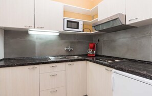 Una cocina equipada con microondas, cafetera y lavavajillas.