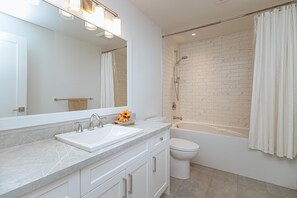 A modern bathroom with a white sink, mirror, and shower. - Premier Oceanfront Luxury in Oak Bay South (Oak Bay South)