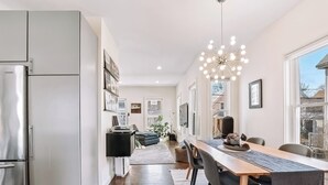 Eine moderne Küche mit Essbereich, Holzboden und einem großen Fenster.