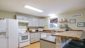 A modern kitchen with white appliances, a wooden countertop, and a coffee sign on the wall. - Silverwood Theme Park + Spirit Lake Retreat (Spirit Lake)