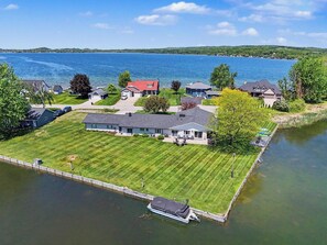 A residential area with houses, a lawn, and a body of water.