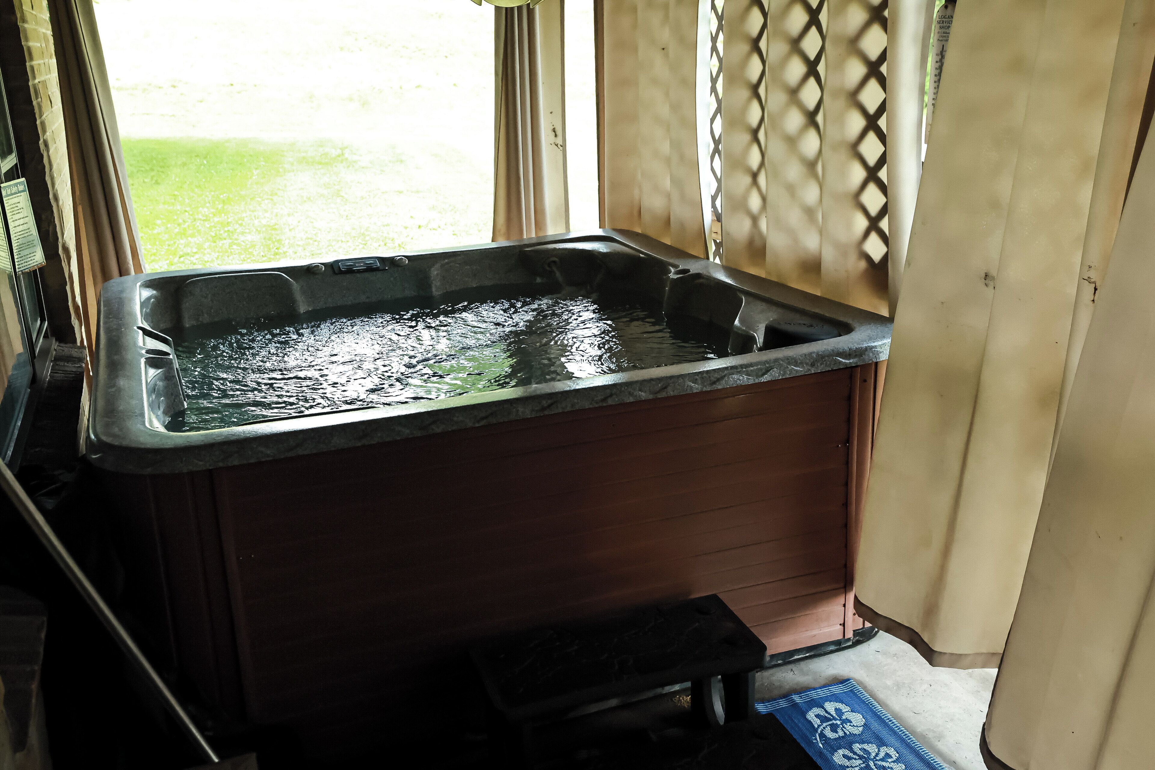 Ein Whirlpool mit Blick auf eine grüne Parklandschaft.