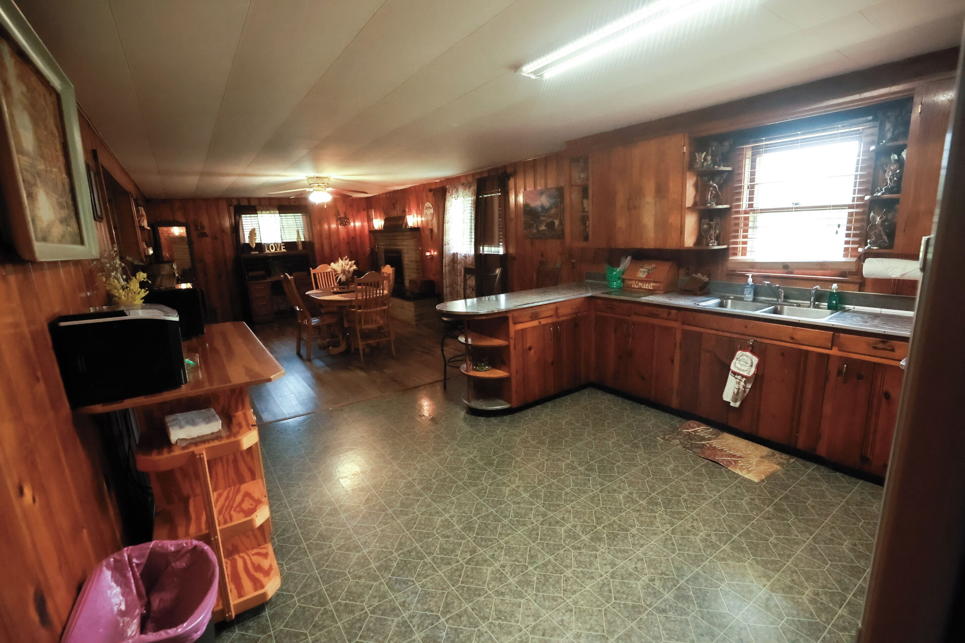 Una cucina con mobili in legno, un lavello e un'area pranzo con sedie.
