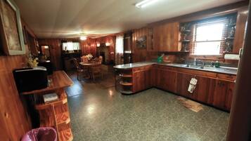 Una cucina con mobili in legno, un lavello e un'area pranzo con sedie.