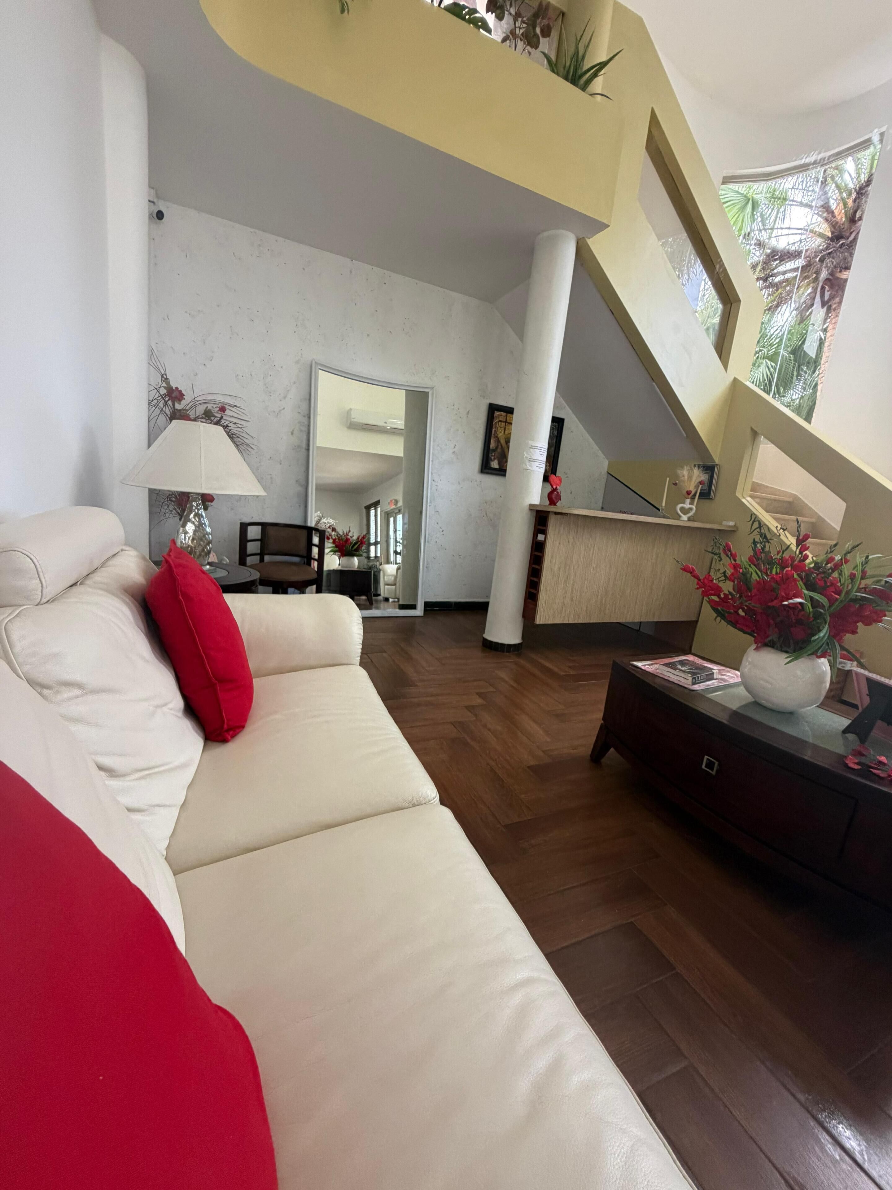 A modern living room with a sofa, a coffee table, and a decorative vase.