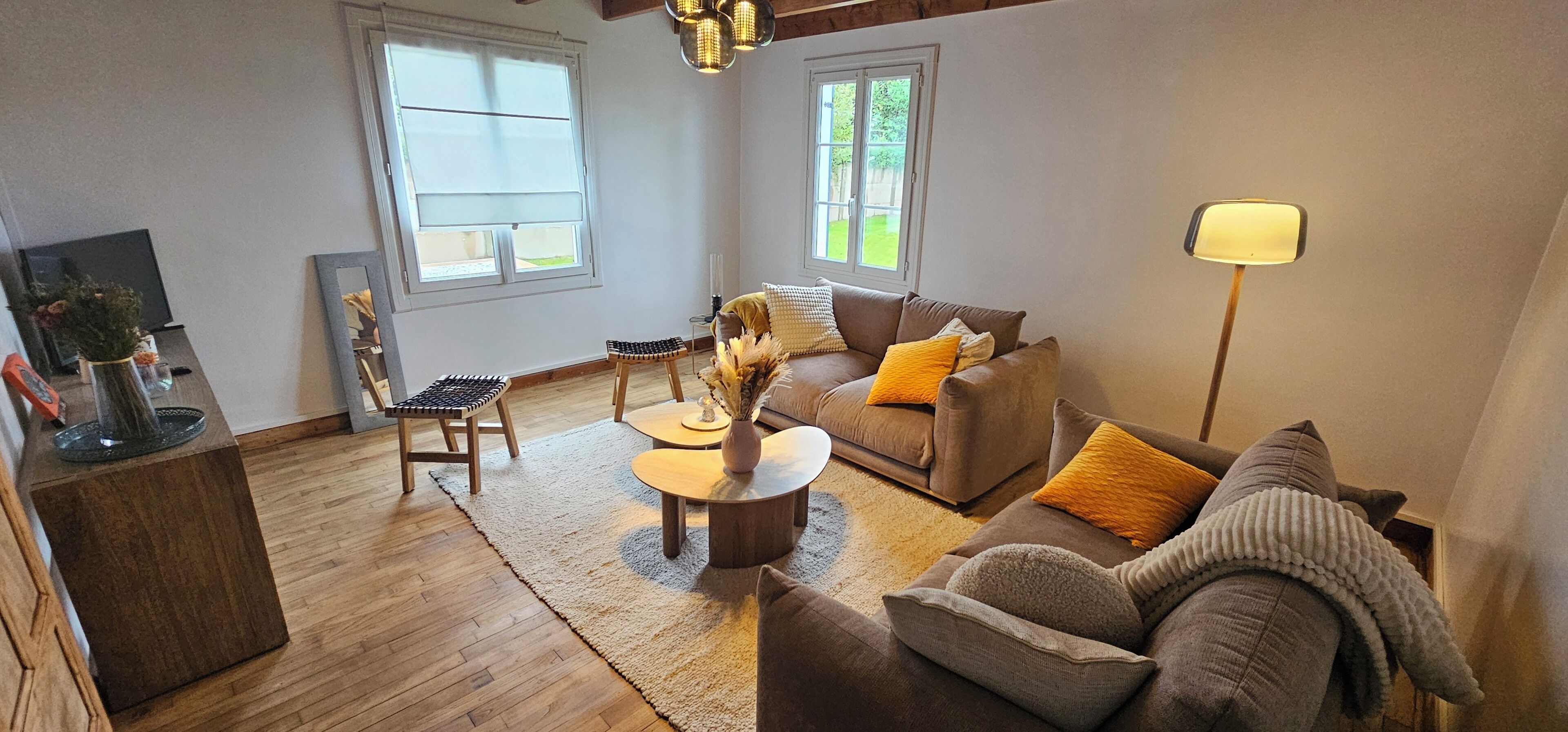 A living room with a brown sofa, a coffee table, a chair, and a TV.