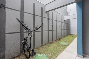 A narrow corridor with a bicycle leaning against a wall, a manhole cover, and a blue-painted pillar. - W/ Balcony 850 m From the Subway Msz0504 (São Paulo)